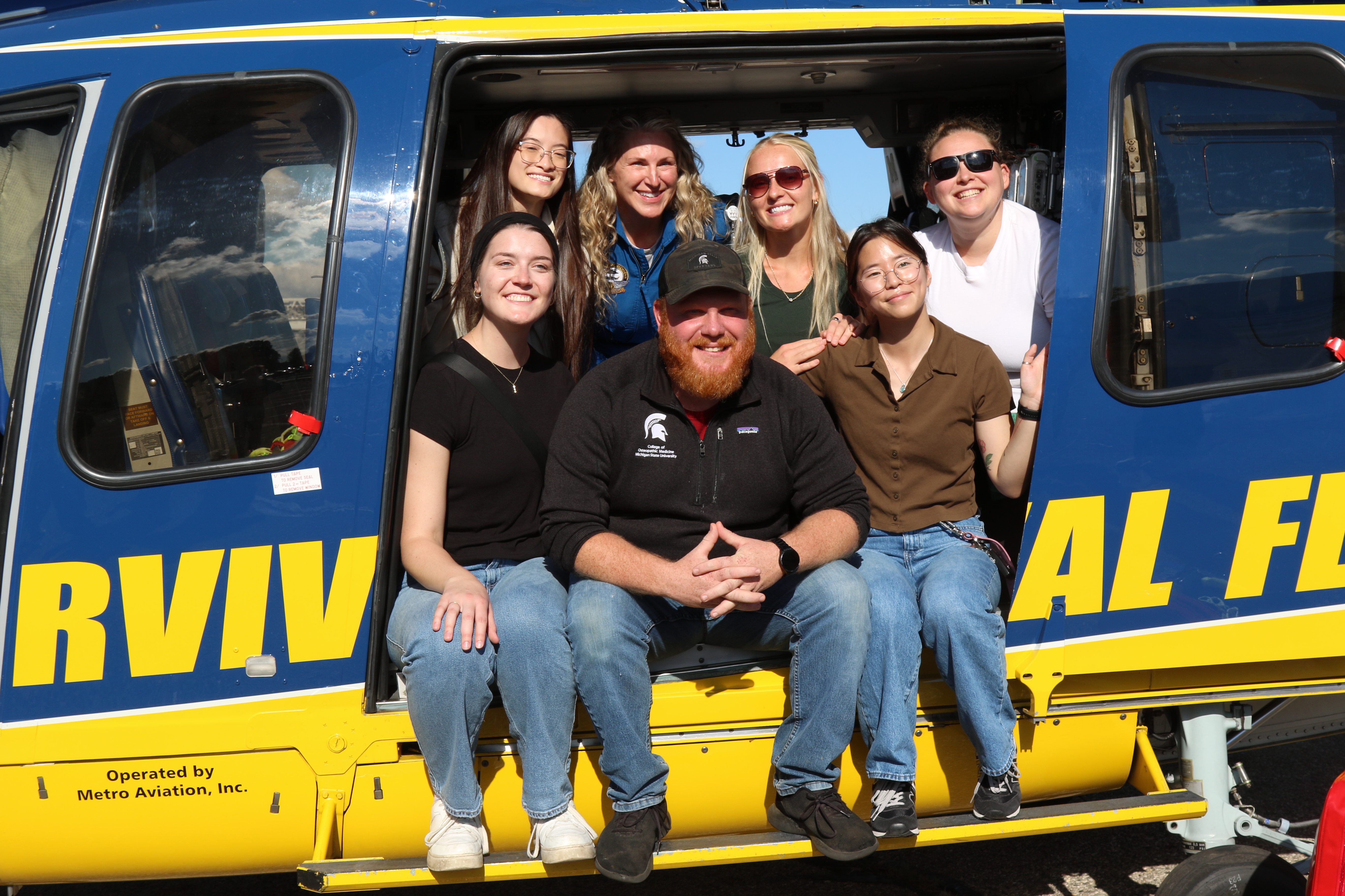MSUCOM Emergency Medicine Club members sit inside the University of Michigan Health Survival Flight helicopter.