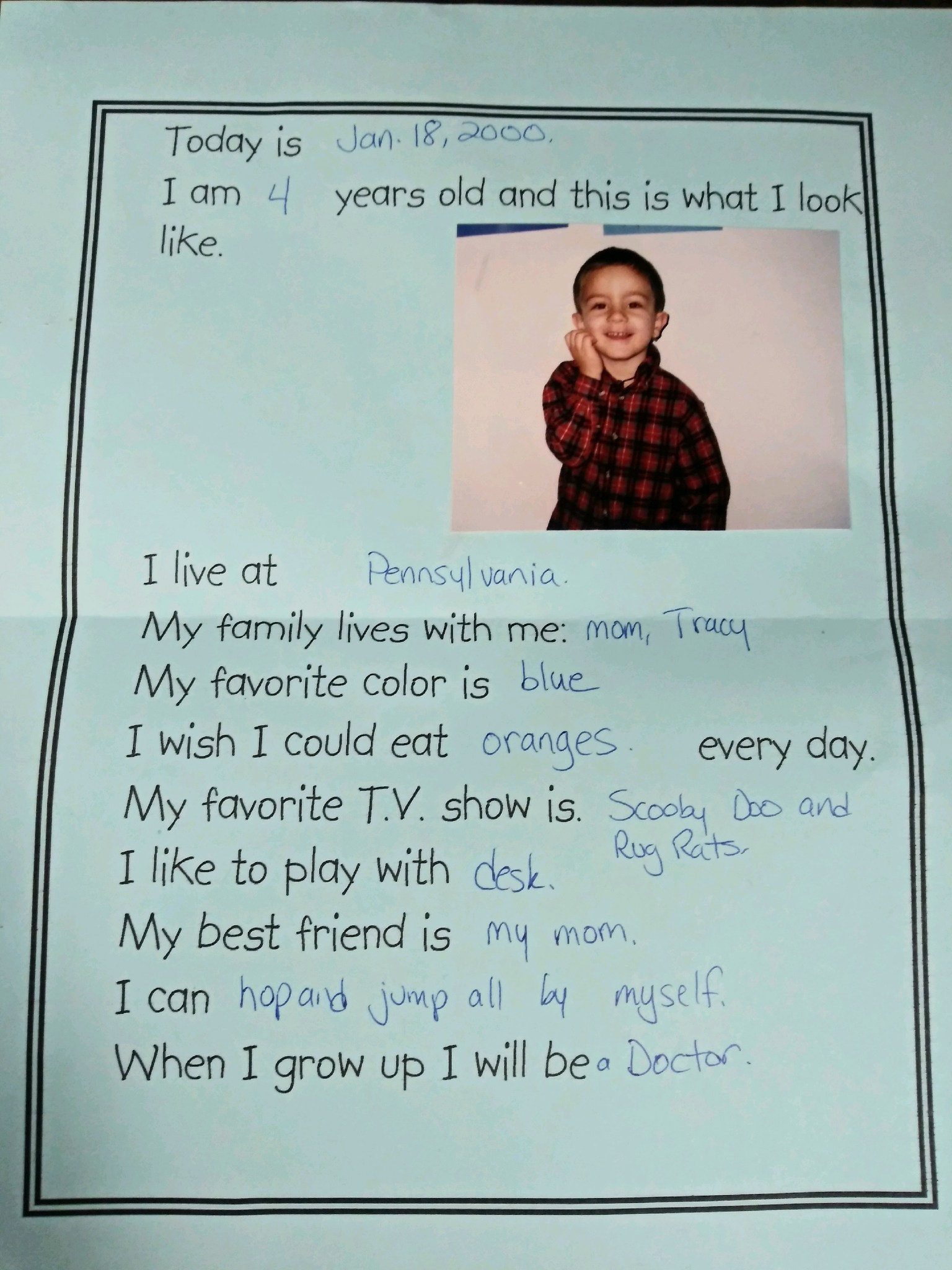 School activity worksheet of Alex Pasculle at four years old writing that he wants to be a doctor when he grows up with a glued photo of Alex on a blue sheet of paper