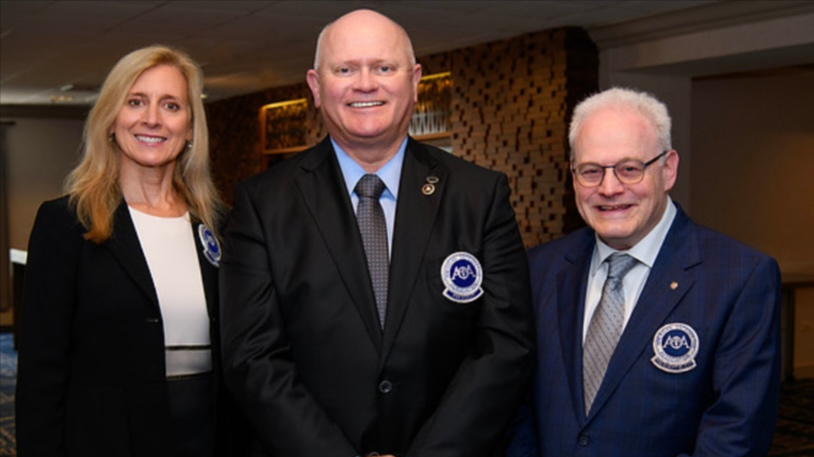 Three AOA board of trustee members in branded back suit jackets. Left to right: Kathleen S. Creason, Richard Thacker, Bruce Wolf