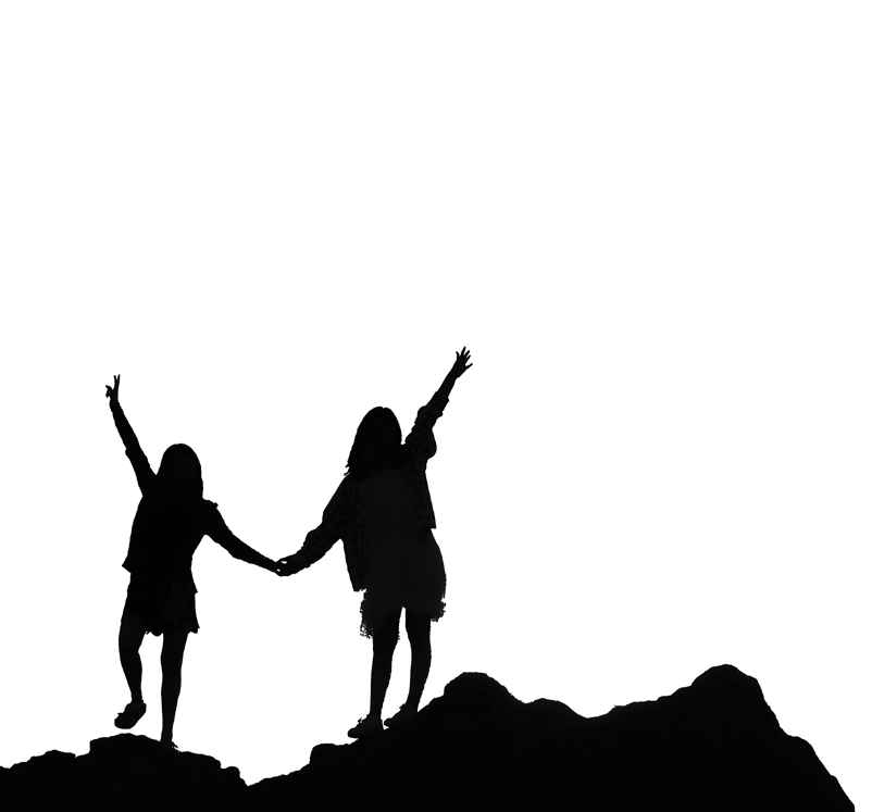  Dark silhouette of two children facing forward holding hands on a rocky surface with the other hand up in the air with excitement