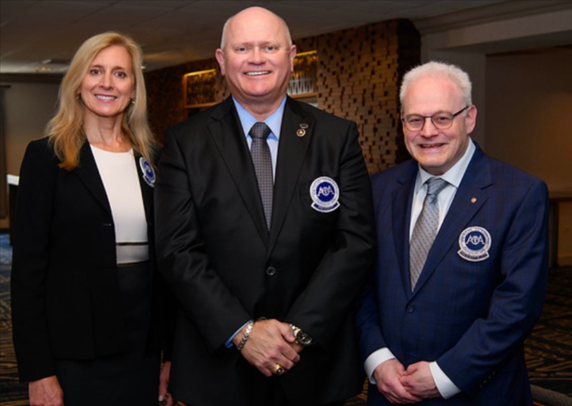 Three AOA board of trustee members in branded back suit jackets. Left to right: Kathleen S. Creason, Richard Thacker, Bruce Wolf